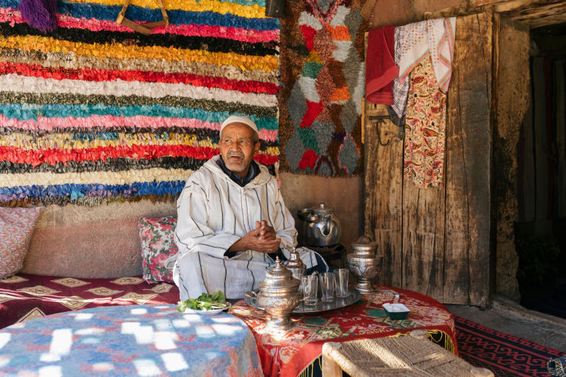 Elderly-Berber-man-sitting-on-the-terrace-of-his-house-preparing-a-tea-Traditional-arabic-hospitality