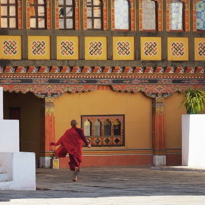 Young monk runs in Paro Dzong, XVII century, Buddhist monastery and a fortress, Bhutan, Asia