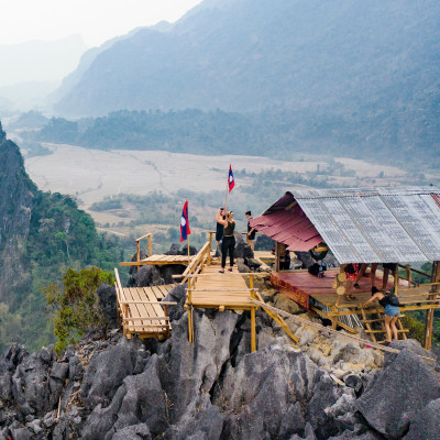 Stunning aerial view of some tourists taking pictures at the beautiful panorama from the Nam Xay viewpoint in Vang Vieng, Laos, Asia