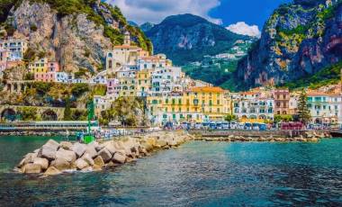 Enchanting Travels Italy Tours Wonderful Italy. The small haven of Amalfi village with a turquoise sea and colorful houses on the slopes of the coast