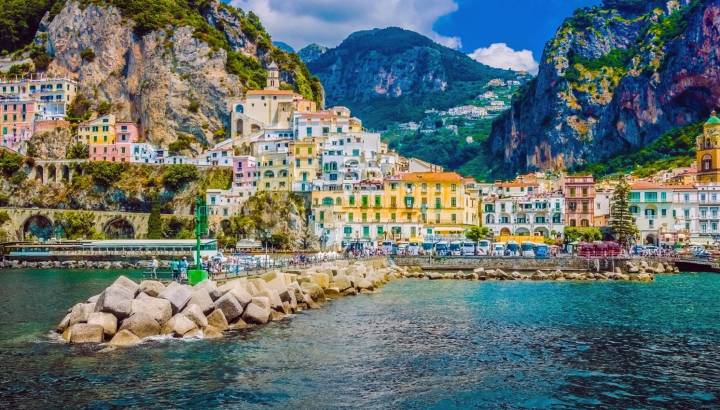 Enchanting Travels Italy Tours Wonderful Italy. The small haven of Amalfi village with a turquoise sea and colorful houses on the slopes of the coast