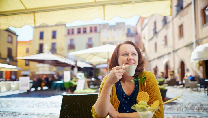 Girl drinking coffee and eating ice cream in cafe in Bosa village, Sardinia, Italy (1)