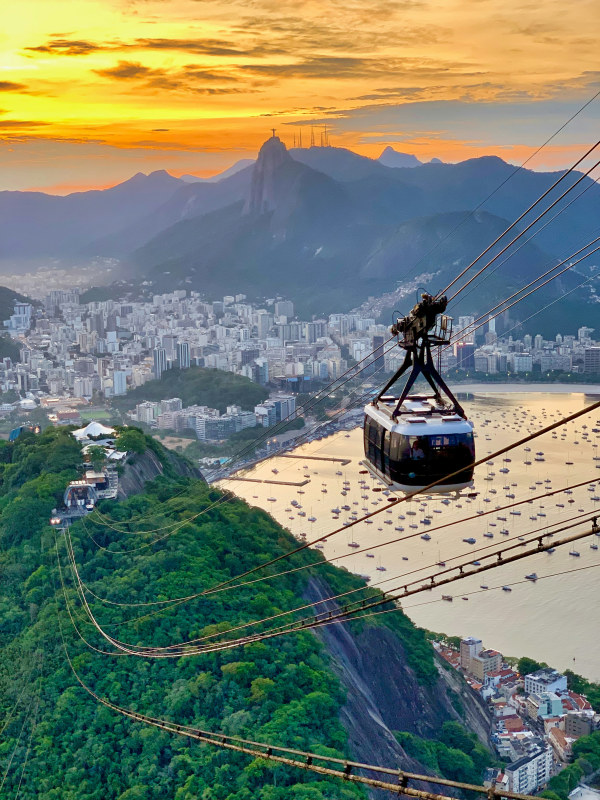 white-cable-car-traversing-on-top-of-hills-overlooking-city-by-bay